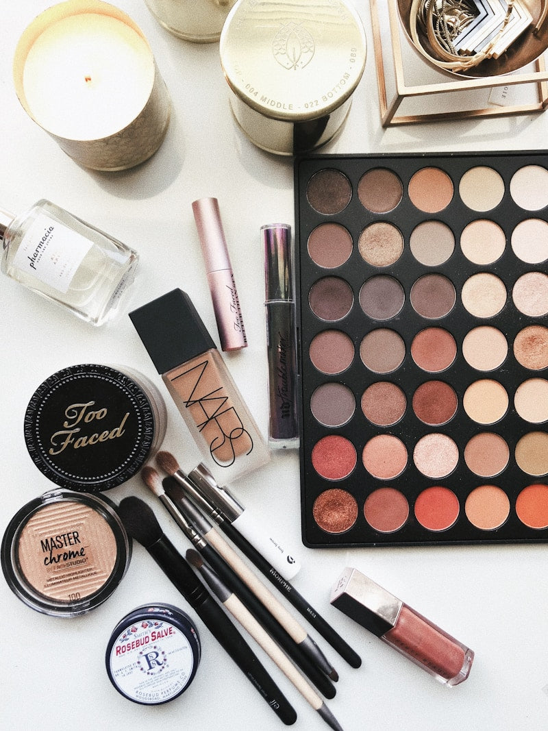 Palette de fards, pinceaux, fond de teint et poudres sur une coiffeuse
