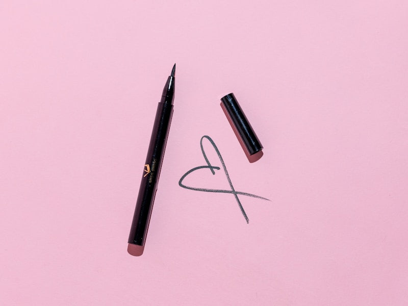 Eye-liner et rouge à lèvres sur fond rose